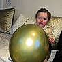 Anas a rejoint le concours — aidez-le/la à gagner de superbes lots ! balloon, celebration, child, curly_hair, cushion, fabric, face, flash, gold_balloon, hand, home_decor, indoor, party, pillow, portrait, reflection, rosy_cheeks, smile, sofa, toddler