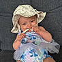 baby, child, hat, polka_dot, sunhat, couch, gray_couch, clothing, onesie, tulle, face, hands, sitting, indoor, cute, smiling, playing, blue, pattern, infant
