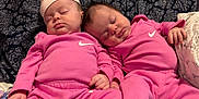 Harley joined the competition — help win amazing prizes! baby, sleeping, pink_clothing, nike_logo, twin_babies, infant, cushion, patterned_background, peaceful, cute, indoor, soft_lighting, relaxing, matching_outfits, newborn, small_hands, resting, portrait, child, cozy