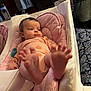 Poppy is registered to the contest to win money with this photo: baby, infant, feet, face, cushion, bassinet, blanket, clothing, indoors, furniture, pacifier, bedroom, curtain, window, pattern, person, pink, white, soft, relaxing