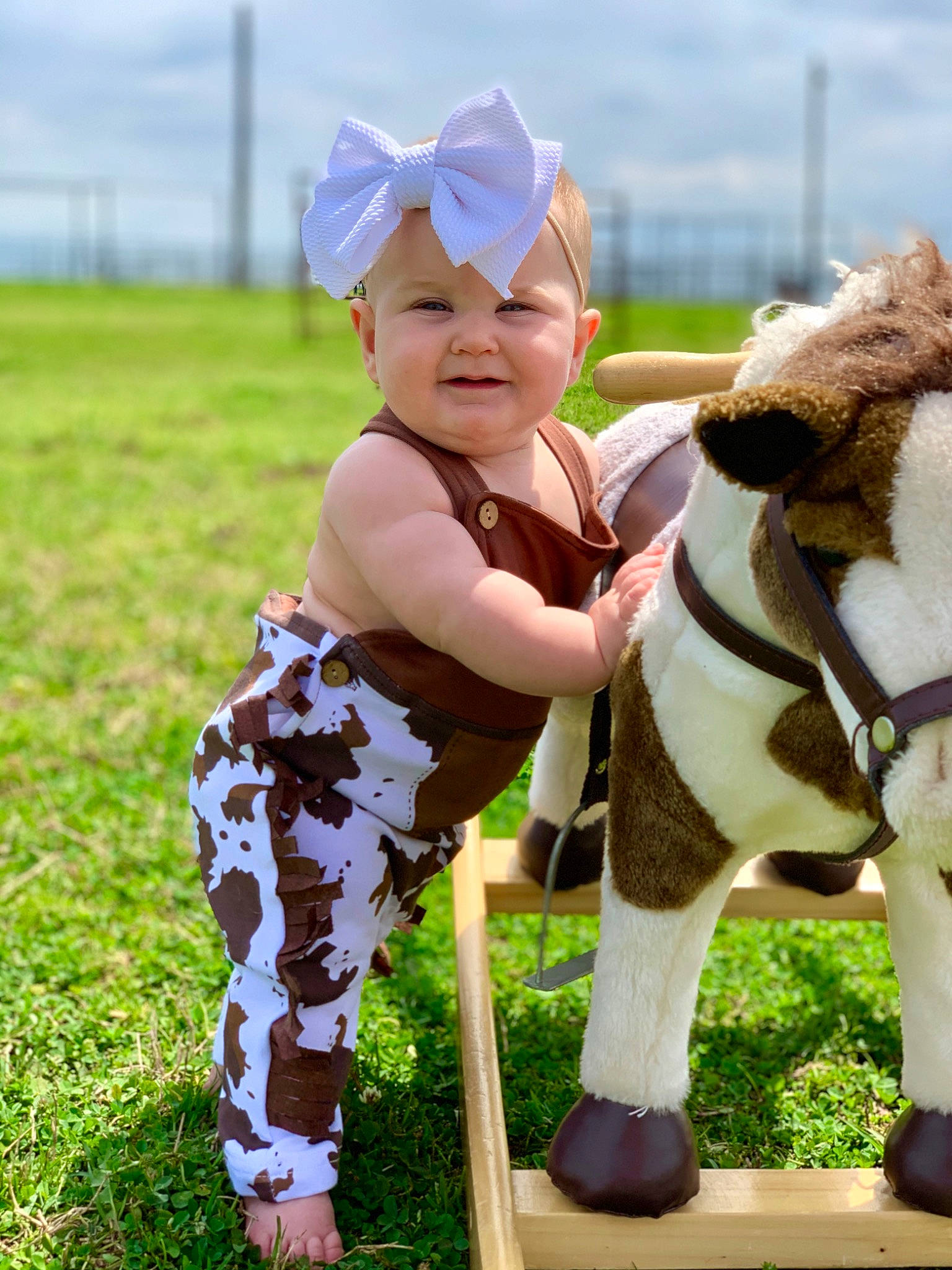 Baker is registered to the contest to win money with this photo: bovine, child, dairy_cow, farm, fawn, grass, grassland, happy, headwear, person, smile, toddler