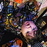 child, toddler, portrait, smiling, happy, face, eyes, hair, pajamas, halloween, colorful, plush_toy, stuffed_animal, bed, blanket, indoor, lying_down, upside_down, cozy, playful