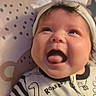 Calliope joined the competition — help win amazing prizes! baby, infant, child, portrait, smiling, open_mouth, tongue, white_bow, headband, dinosaur, pajamas, striped_sleeve, blanket, bed, indoor, close_up, face, eyes, cute, patterned_background