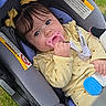 baby, child, infant, car_seat, pacifier, yellow_outfit, hair_bows, blue_eyes, portrait, sitting, outdoor, grass, vehicle, travel,  안전, close_up, adorable, looking_at_camera, baby_clothing, daylight