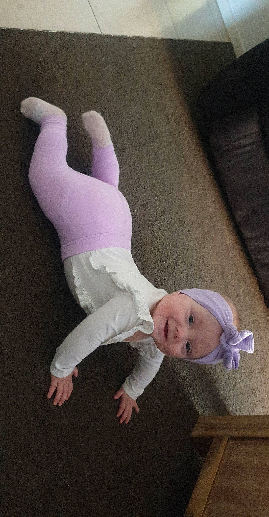 Skyla is registered to the contest to win money with this photo: child, comfort, flooring, foot, fun, gesture, happy, headwear, human_leg, knee, linens, person, sleeve, smile, sock, sportswear, textile, thigh, thumb, toy