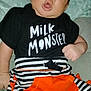 Kylon joined the competition — help win amazing prizes! baby, black_shirt, blanket, casual, child, clothing, comfortable, cute, expression, face, hand, indoors, infant, orange_patch, person, portrait, sitting, soft_texture, striped_pants, young_child