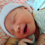 Kylon joined the competition — help win amazing prizes! baby, child, close_up, cozy, cute, face, hand, hat, indoors, infant, newborn, patterned_blanket, peaceful, portrait, resting, skin, sleeping, smiling, soft, striped_clothing