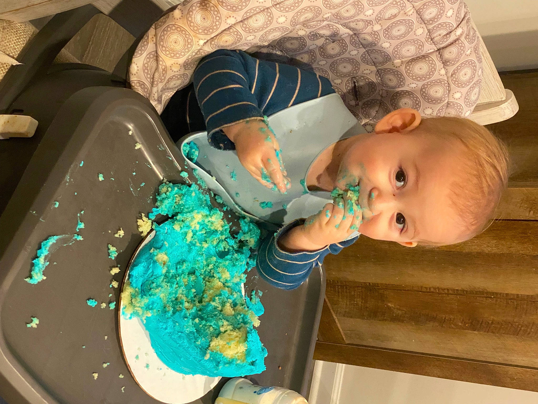 Callan is registered to the contest to win money with this photo: arm, baby, baby_products, baby_toddler_clothing, birthday_cake, cake, cake_decorating, chair, child, dessert, electric_blue, finger, food, fun, mouth, pattern, person, plate, sugar_cake, tableware