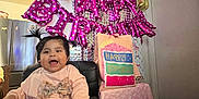 Evangeline is registered to the contest to win money with this photo: baby, balloons, birthday, celebration, chair, child, clothing, decorations, festive, first_birthday, gift_bags, happy, home, indoors, party, pigtails, pink, present, smile, table