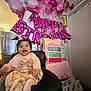 baby, child, birthday, balloons, pink, party, celebration, gift_bags, chair, pigtails, smile, indoors, clothing, happy, decorations, first_birthday, present, table, home, festive