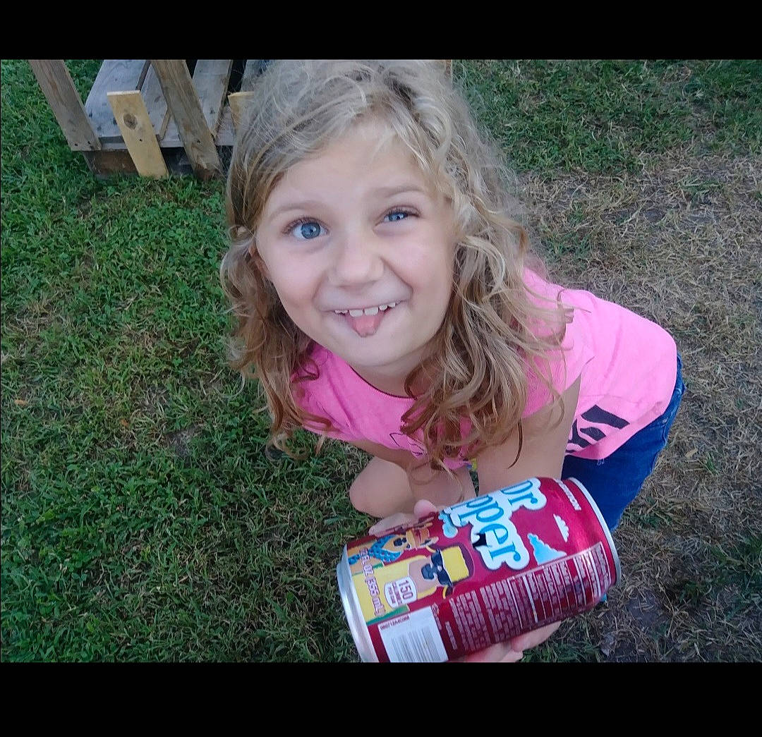 Lillian is registered to the contest to win money with this photo: beauty, blond, child, cool, fruit, fun, grass, happy, joy, laugh, people_in_nature, person, photo_caption, pink, plant, play, sitting, smile, soil, t_shirt
