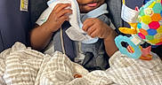 Kason joined the competition — help win amazing prizes! baby, infant, child, smiling, car_seat, safety_harness, blanket, burp_cloth, toy, colorful_toy, rattle, portrait, sitting, indoors, vehicle, cozy, happy, face, hands, photography