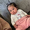 baby, blanket, cartoon, child, couch, cozy, face, furniture, hair_bows, hello_kitty, indoors, infant, photography, pigtails, pink_clothing, portrait, sitting, smiling, sofa, white_shirt