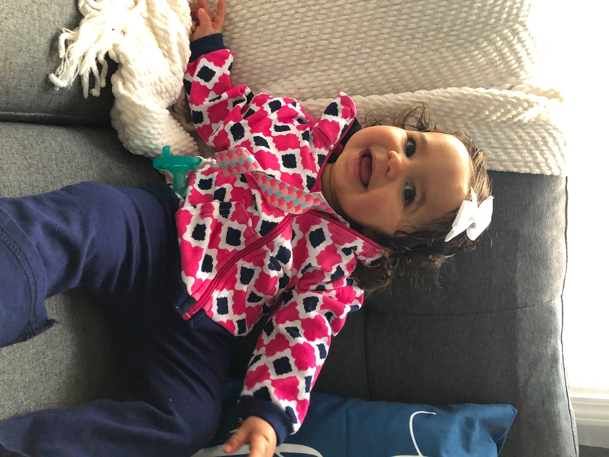 Arielle is registered to the contest to win money with this photo: bedding, child, comfort, couch, flooring, fur, headwear, human_leg, joint, knee, linens, magenta, pattern, person, plaid, room, shoulder, sitting, sleeve, textile