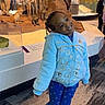 child, smiling, posing, museum, lion, wildlife, exhibit, blue_jacket, blue_pants, braids, indoor, carpet, display_case, animal_models, playful, happy, person, standing, head_tilt, footwear