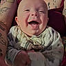 baby, smile, happy, infant, tattoo, arm, clothing, pattern, person, closeup, face, cute, joy, skin, child, portrait, sitting, warmth, comfort, expression