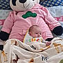baby, blanket, plush_toy, panda, pink_hoodie, animal_print, bed, pillow, child, infant, cute, soft_toys, sleeping_area, comfort, cozy, resting, indoor, portrait, toddler, nursery