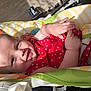 baby, infant, smile, red_clothing, baby_chair, sunlight, happy, cute, child, skin, hand, face, indoors, comfort, small_hands, patterned_fabric, seat, toddler, playful, relaxation