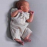 Carter is registered to the contest to win money with this photo: newborn, baby, infant, sleeping, romper, striped_clothing, soft_surface, profile, peaceful, tiny_toes, delicate, cute, small, child, portrait, closeup, indoors, human, resting, peace