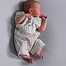 newborn, baby, infant, sleeping, romper, striped_clothing, soft_surface, profile, peaceful, tiny_toes, delicate, cute, small, child, portrait, closeup, indoors, human, resting, peace