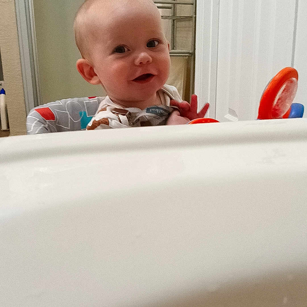 Colter is registered to the contest to win money with this photo: baby, bathing, bathtub, bodypart, cutlery, door, face, finger, hand, happy, head, indoors, mouth, person, photography, portrait, smile, spoon, teeth, tub