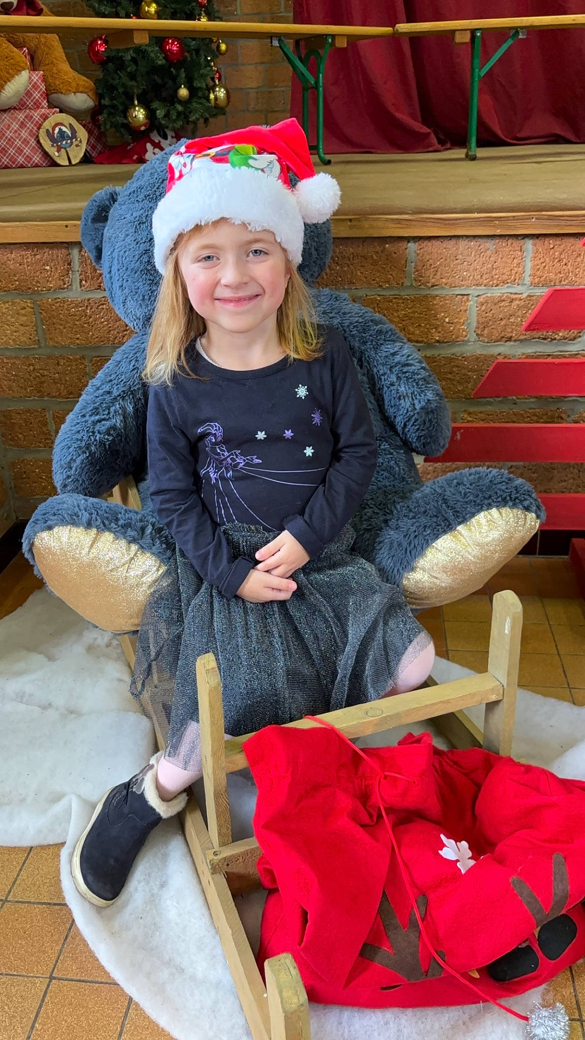 Victoire participe au concours pour gagner de l'argent avec cette photo : chair, child, costume_hat, event, eye, face, fashion_accessory, fun, furniture, happy, headwear, holiday, joy, lap, person, plant, room, sitting, smile, sock