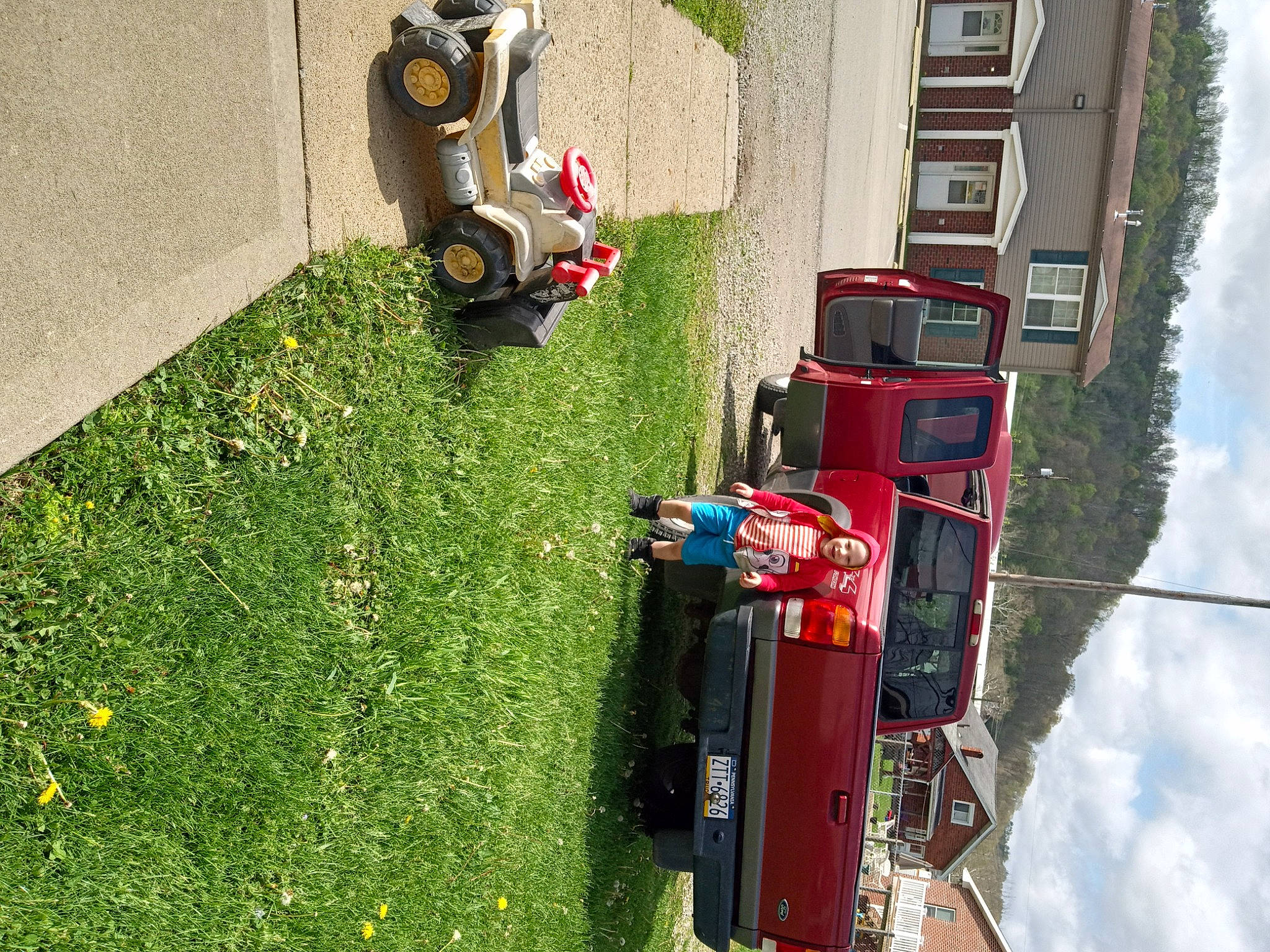 Adam is registered to the contest to win money with this photo: asphalt, automotive_exterior, automotive_lighting, automotive_tire, car, cloud, grass, green, groundcover, headwear, landscape, mode_of_transport, motor_vehicle, person, plant, red, sky, tire, tree, vehicle