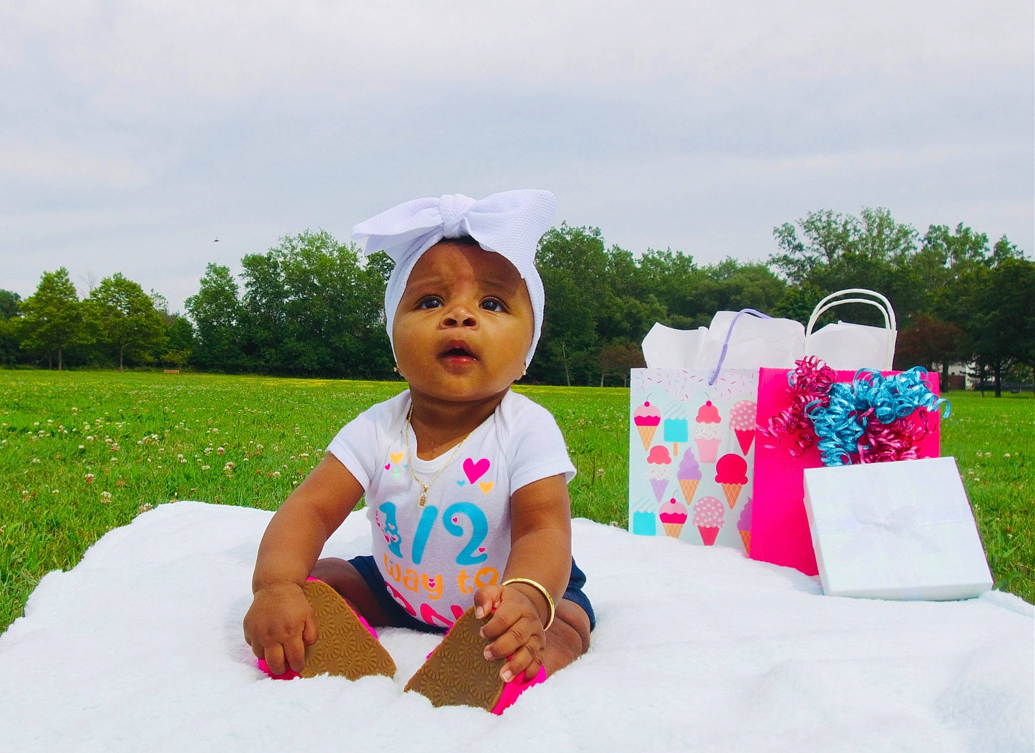 Timia is registered to the contest to win money with this photo: baby, baby_toddler_clothing, child, event, fun, grass, grassland, happy, lawn, leisure, magenta, people_in_nature, person, pink, plant, recreation, sitting, sky, toddler, travel