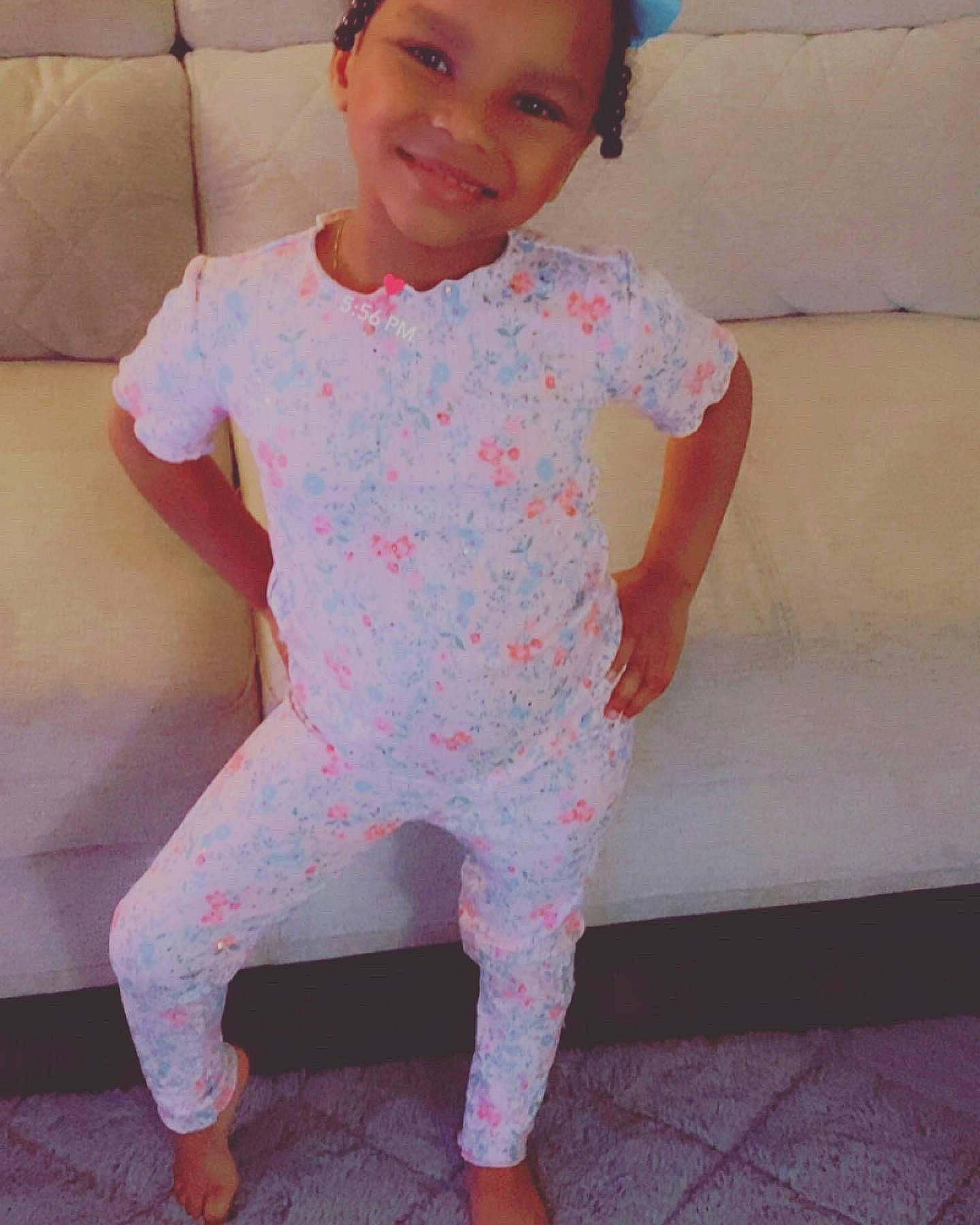 Aleah is registered to the contest to win money with this photo: baby_toddler_clothing, facial_expression, head, human_body, joy, knee, leg, lip, neck, one_piece_garment, outerwear, pattern, person, pink, skin, sleeve, smile, sportswear, t_shirt, thigh