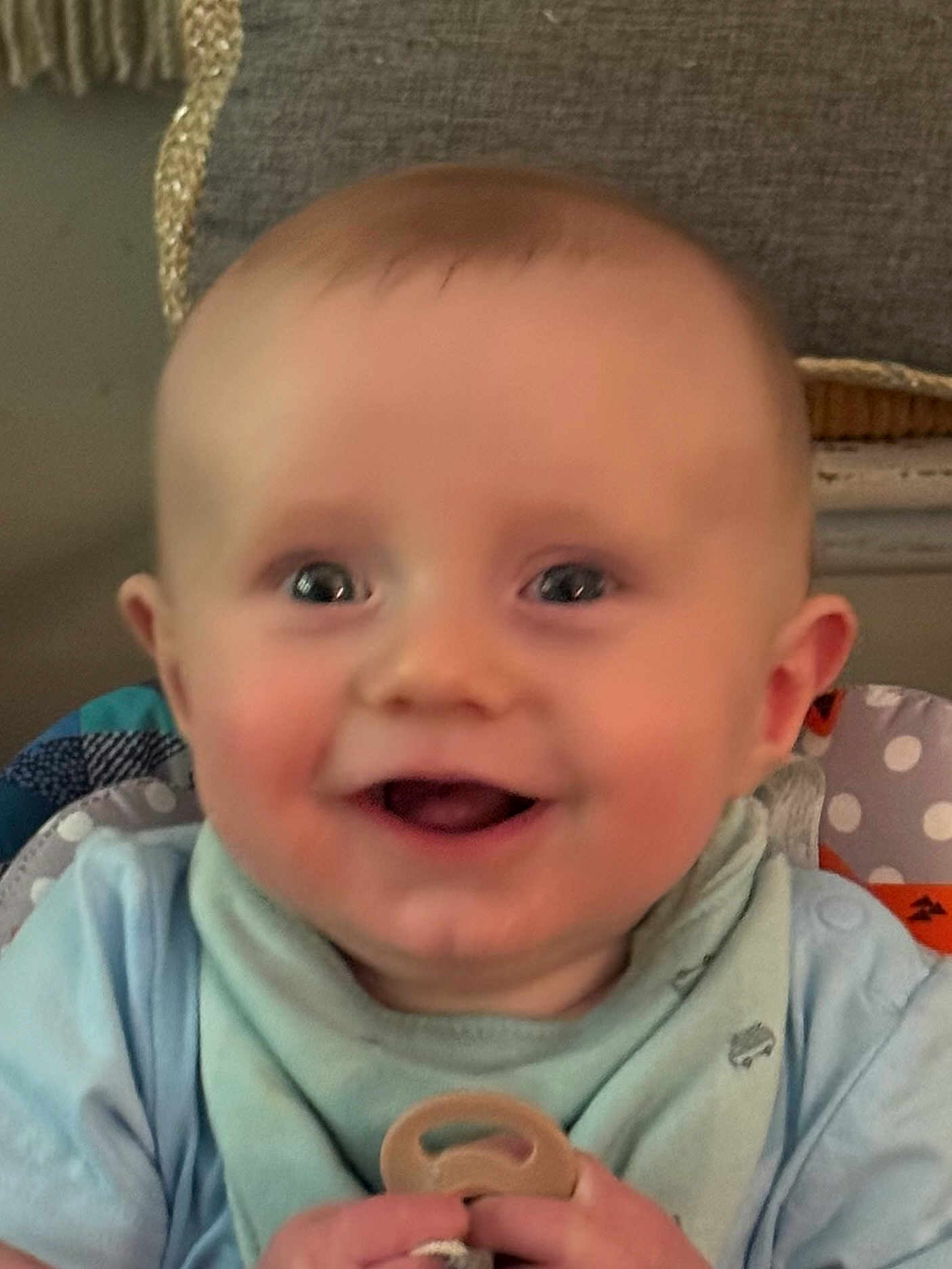Oak joined the competition — help win amazing prizes! baby, infant, smiling, face, eyes, mouth, hands, pacifier, bib, clothing, blue, indoor, cushion, fabric, background, portrait, child, cute, happy, closeup