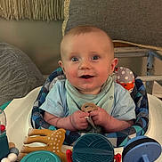 Oak is registered to the contest to win money with this photo: baby, infant, smiling, teether, toy, baby_seat, indoor, child, cute, happy, blue_clothing, face, hand, seat, cushion, play, expression, person, comfort, home