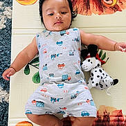 Aariv joined the competition — help win amazing prizes! baby, infant, child, play_mat, lion_design, plush_toy, spotted_dog, grey_outfit, vehicles_print, indoor, carpet, cute, lying_down, calm_expression, black_hair, soft_lighting, colorful, toy, childhood, floor