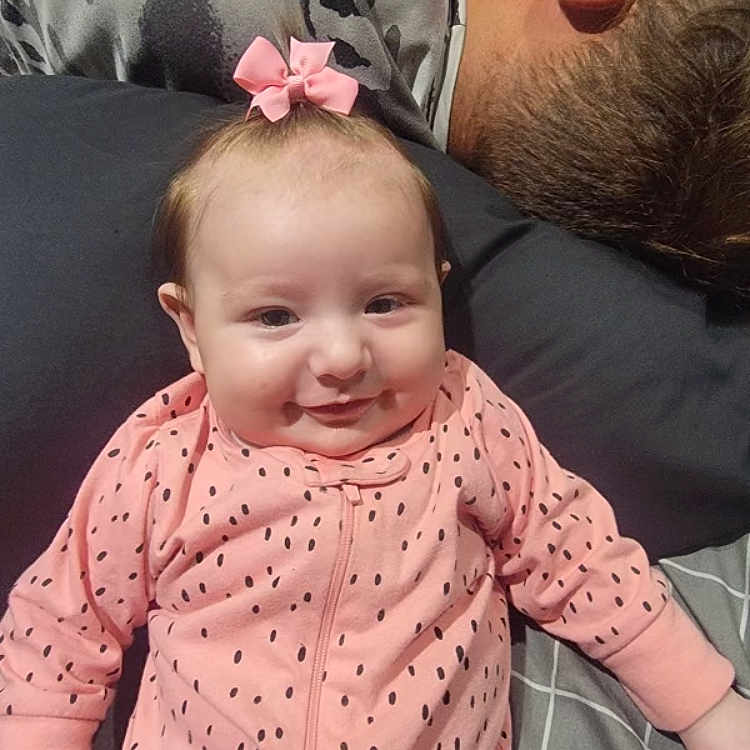 Kinsler joined the competition — help win amazing prizes! adult, baby, bed, blanket, cozy, cute, face, family, hair, indoor, infant, man, person, pillow, pink_bow, pink_onesie, polka_dots, resting, sleeping, smiling