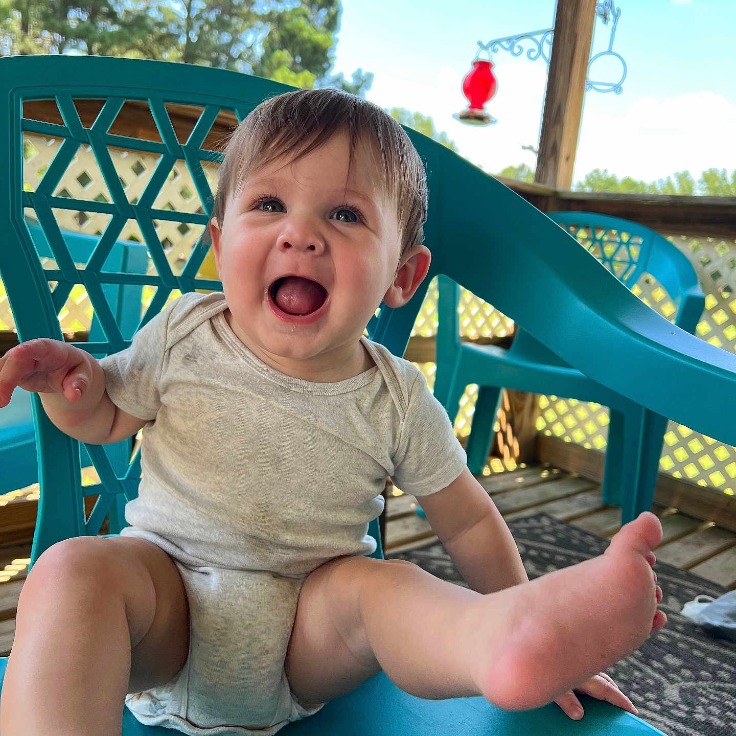 Dakota is registered to the contest to win money with this photo: baby, clothing, diaper, face, furniture, grass, happy, head, outdoorplayarea, outdoors, person, photography, plant, playarea, portrait, pottedplant, shorts, sitting, summer, t_shirt