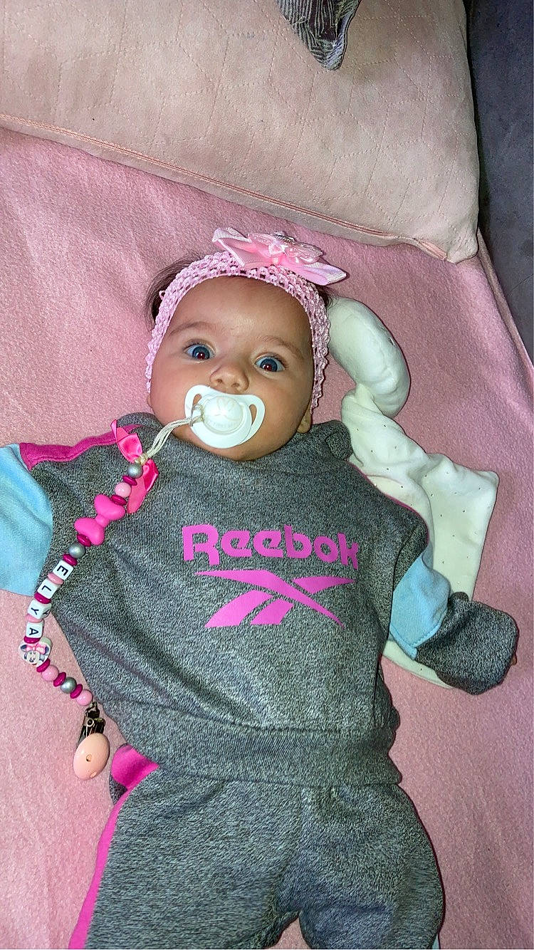 Elya participe au concours pour gagner de l'argent avec cette photo : baby, baby_products, baby_toddler_clothing, cap, cheek, clothing, doll, face, head, headgear, headwear, knit_cap, magenta, person, pink, purple, sleeve, stuffed_toy, toddler, toy