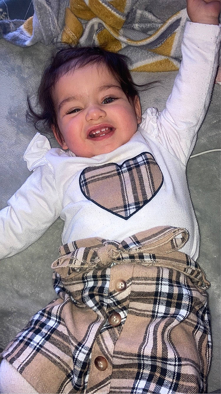 Elya participe au concours pour gagner de l'argent avec cette photo : arm, baby_toddler_clothing, cheek, eye, gesture, hand, happy, human_body, lip, mouth, neck, organ, outerwear, person, plaid, skin, sleeve, smile, tartan, textile