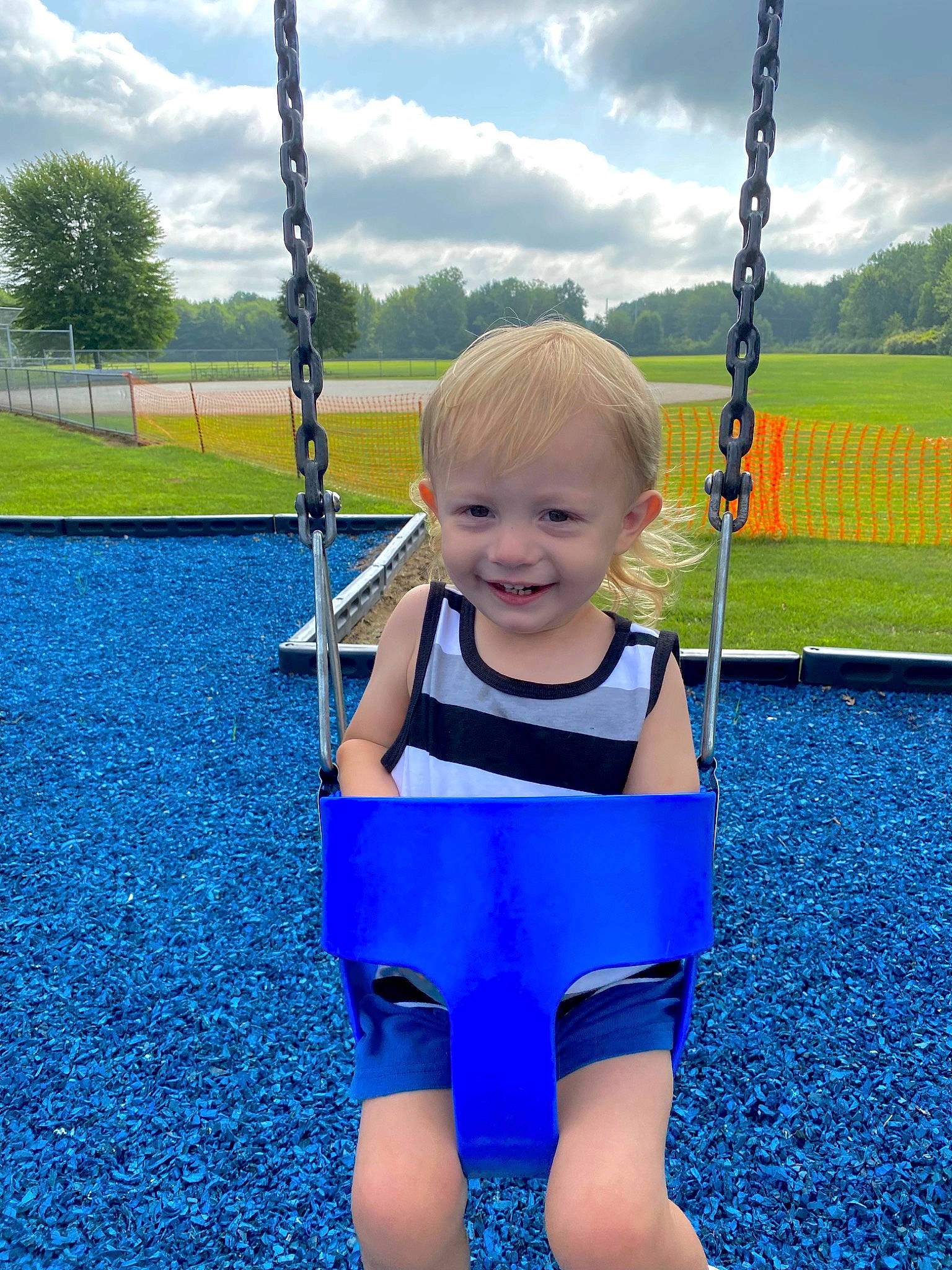 Kaiden is registered to the contest to win money with this photo: azure, baby, blue, cloud, eye, fun, grass, happy, joy, leisure, line, person, photograph, plant, playground, sky, sleeve, smile, standing, swing