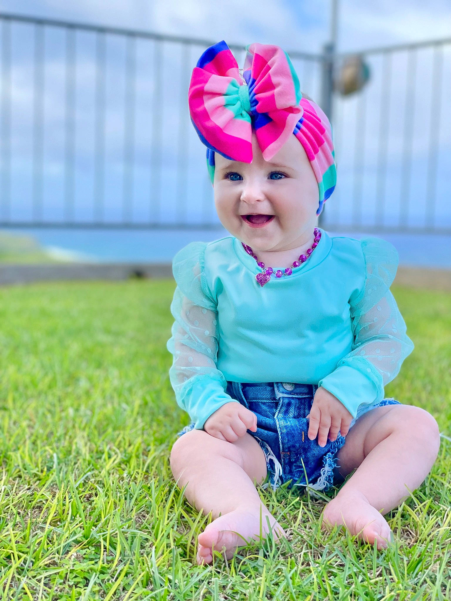 Ella is registered to the contest to win money with this photo: baby, baby_toddler_clothing, child, clothing, electric_blue, eye, face, flash_photography, fun, grass, grassland, happy, head, headwear, leisure, magenta, people_in_nature, person, pink, smile
