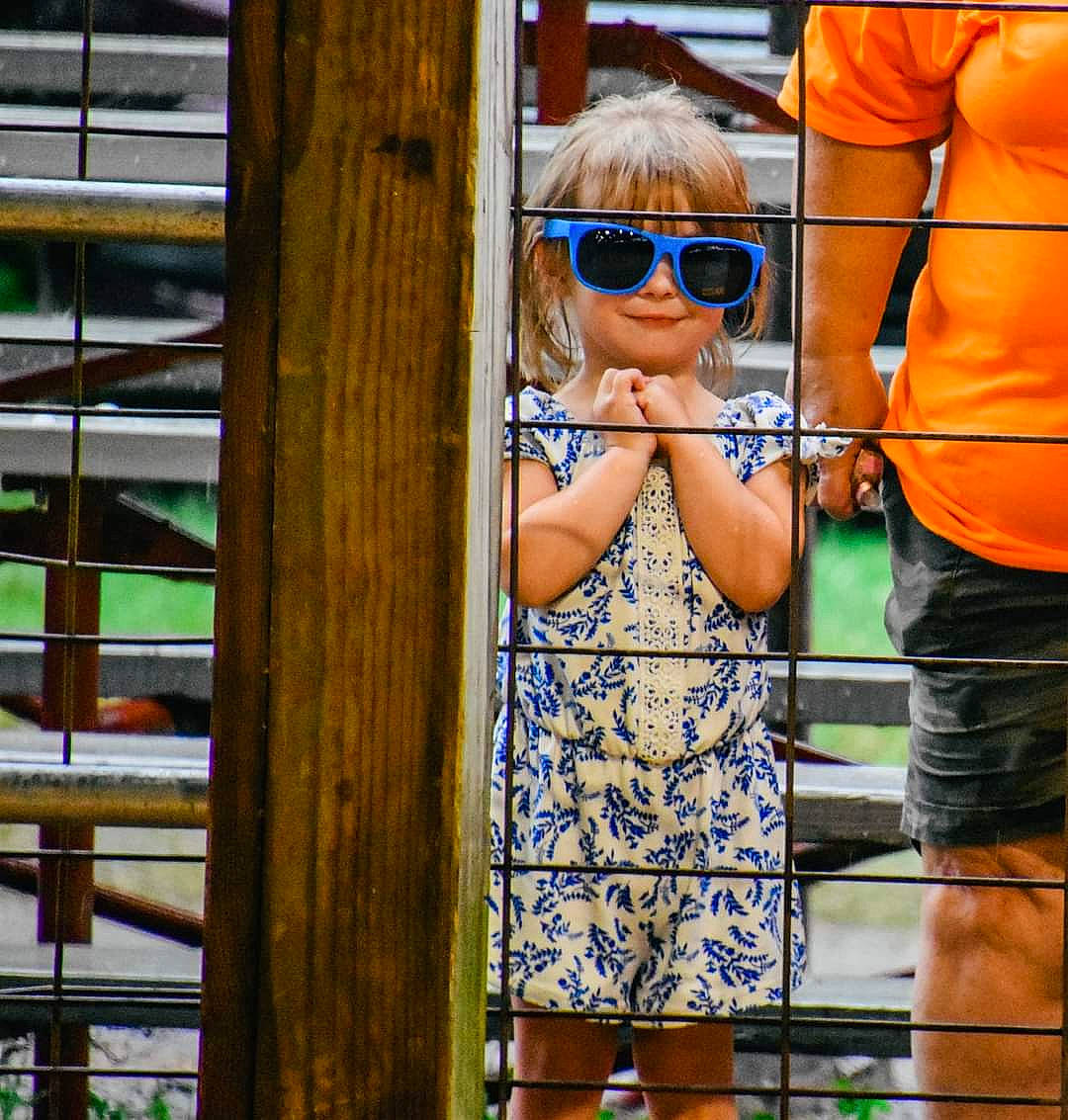 Ellie is registered to the contest to win money with this photo: cool, denim, electric_blue, eyewear, fun, glasses, goggles, human_leg, leisure, person, personal_protective_equipment, recreation, shoulder, sleeve, sunglasses, t_shirt, thigh, toddler, travel, vision_care