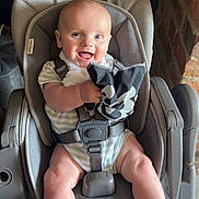 Oliver joined the competition — help win amazing prizes! baby, car_seat, smiling, child, infant, happy, person, seatbelt, clothing, indoor, fabric, arm, leg, head, holding, toy, cute, face, furniture, safety