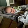 baby, infant, smile, face, baby_seat, blanket, indoor, happy, child, clothing, carrying_seat, wooden_legs, soft_texture, portrait, comfort, young_child, baby_bib, baby_toy, baby_accessory, relaxing