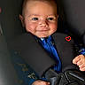 baby, child, infant, smiling, face, portrait, car_seat, safety_harness, seatbelt, vehicle_interior, blue_clothing, brown_hair, happy, sitting, indoors, close_up, photography, heart_symbol, hands, safe_travel