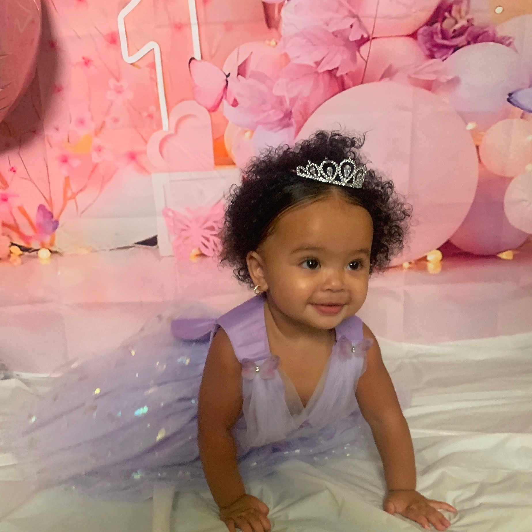 Ahnila is registered to the contest to win money with this photo: background, balloons, birthday, butterflies, celebration, child, crawling, curly_hair, cute, dress, earrings, happy, lavender, pink, princess, purple, smiling, tiara, toddler, white_sheet