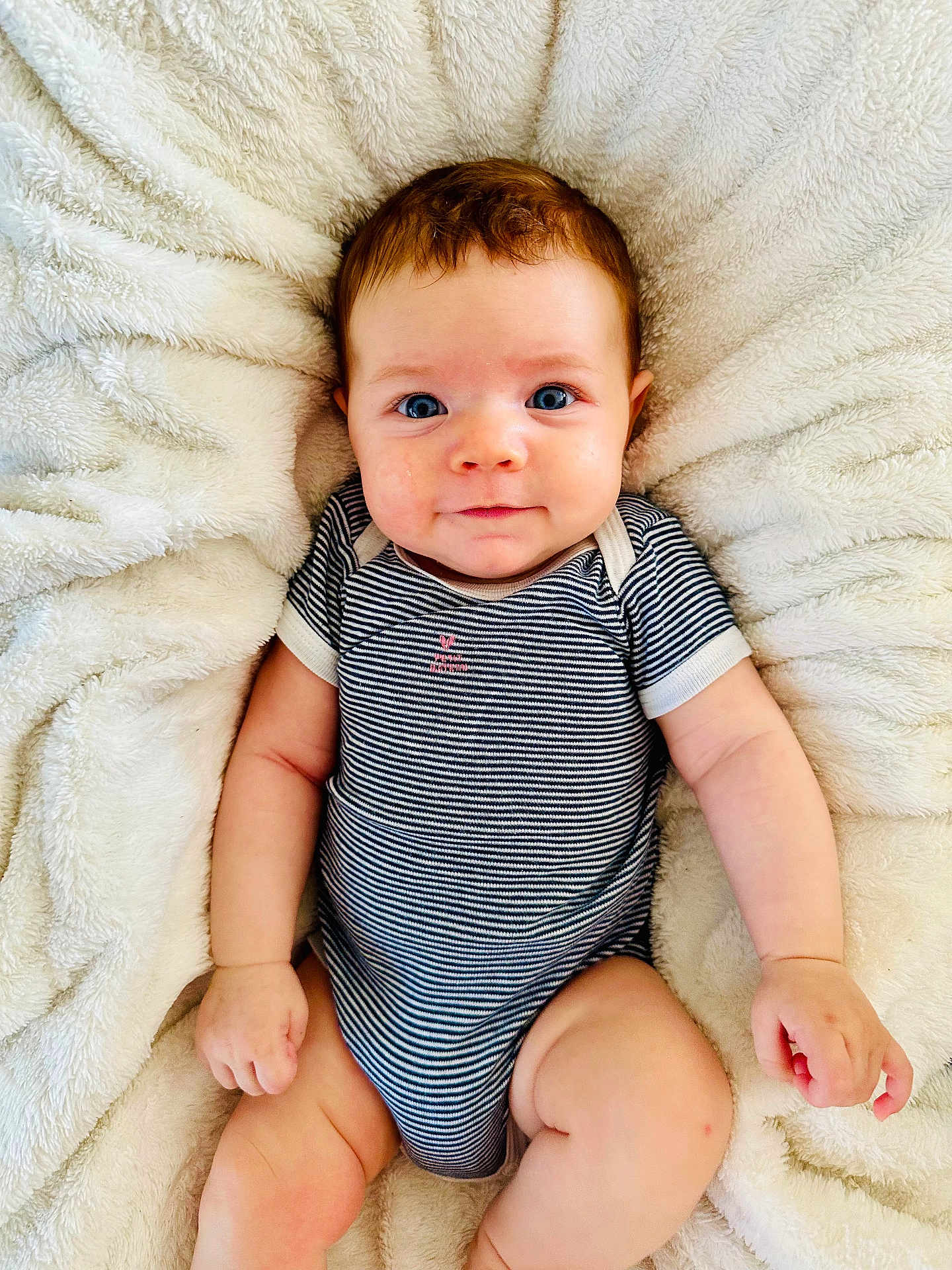 Constance a rejoint le concours — aidez-le/la à gagner de superbes lots ! baby, infant, child, smiling, blue_eyes, striped_clothing, onesie, soft_blanket, fluffy, cute, portrait, skin, hand, leg, lying_down, comfort, indoors, young, person, happy