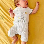 Constance participe au concours pour gagner de l'argent avec cette photo : baby, infant, onesie, yellow, bed, sheet, cute, surprised, face, child, newborn, lying_down, clothing, expression, skin, head, person, sleepwear, koala, text
