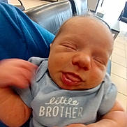 Daniel joined the competition — help win amazing prizes! baby, newborn, infant, blue_onesie, little_brother, tongue_out, close_up, person, hand, waiting_room, chair, floor, tile, shirt, skin, face, cute, sleepy, holding, indoor