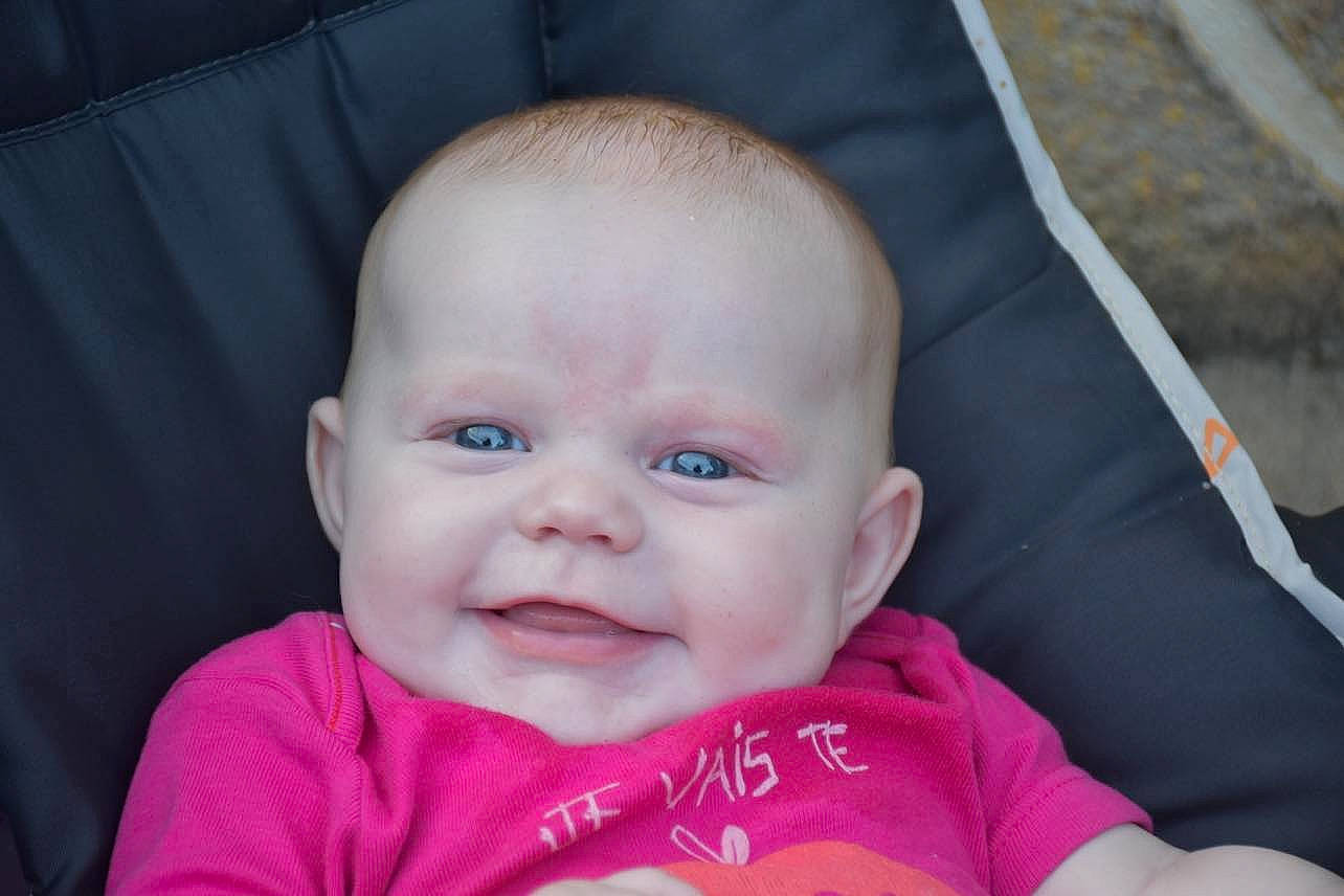 Lénaya participe au concours pour gagner de l'argent avec cette photo : baby, baby_carriage, baby_products, baby_toddler_clothing, cheek, child, comfort, fashion_accessory, fun, grass, happy, iris, joy, lip, magenta, nose, person, sitting, skin, smile