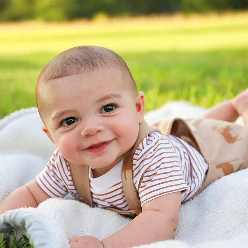 Amari joined the competition — help win amazing prizes! baby, blanket, clothing, face, grass, happy, head, laughing, lawn, nature, outdoors, pants, park, person, photography, plant, portrait, smile, summer, t_shirt