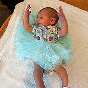 Oaklee is registered to the contest to win money with this photo: baby, infant, tutu, dress, blue, blanket, white, cute, newborn, socks, soft, laying, arms_up, clothing, person, child, sleepwear, bed, resting, indoors
