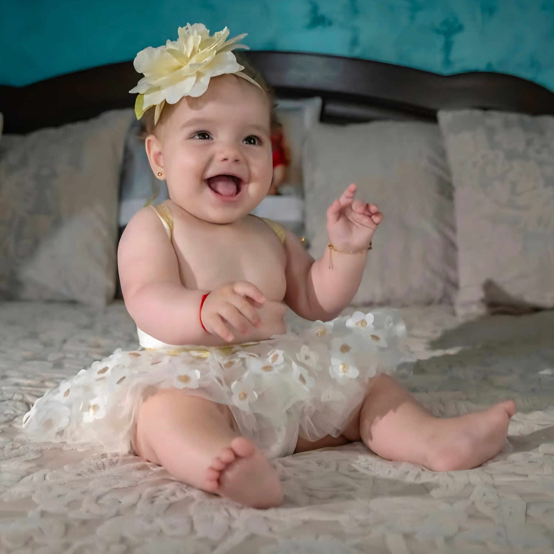 Sofia is registered to the contest to win money with this photo: apparel, baby, bed, blanket, child, cute, flower_headband, foot, hand, happy, headwear, indoors, infant, joyful, pillow, portrait, sitting, skin, smiling, tutu